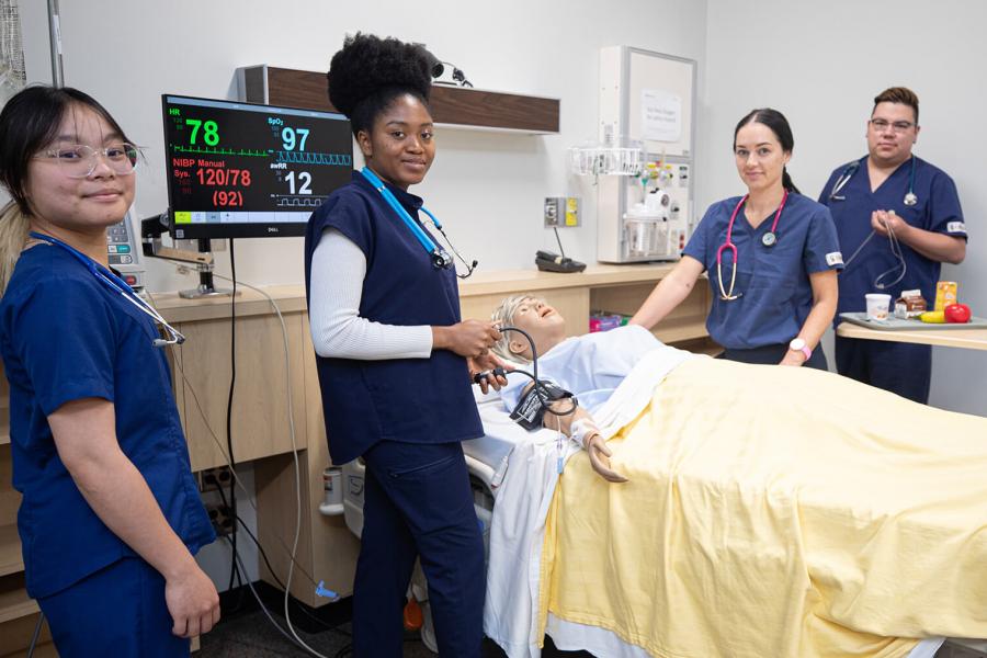 Nursing students working on a simulation patient.